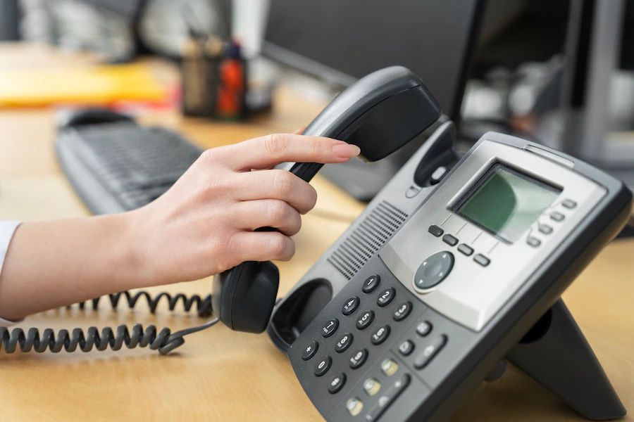 close up of person's hand answering a phone call at a call center