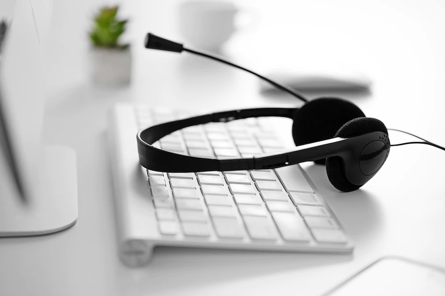 a black headset laying on a white keyboard showing that agents are taking a break from the call center which has high agent turnover