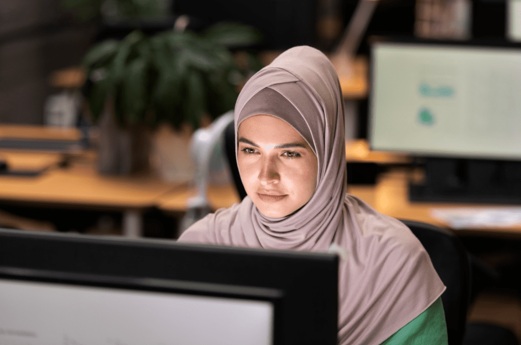 Woman working on a computer in a diverse workplace