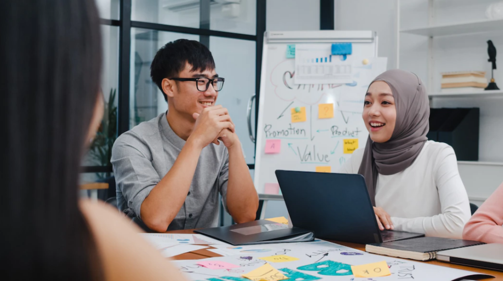 A team of men and women sit around a table to discuss customer success in digital transformation