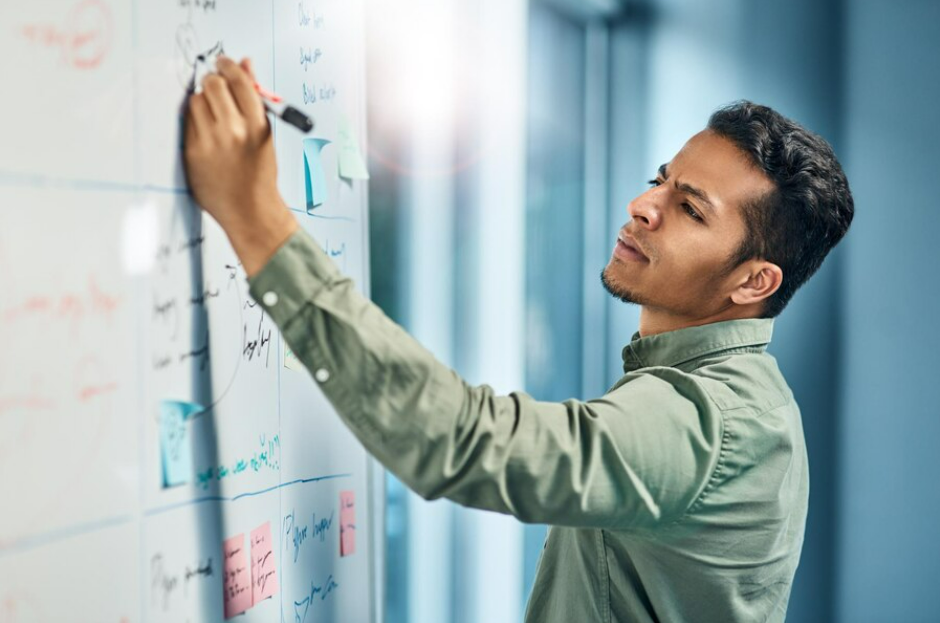 A man jots down notes on a whiteboard for customer success in digital transformation