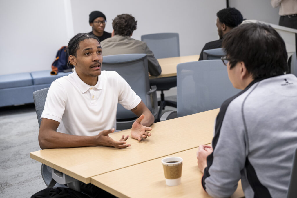 A group of students talking during a low-code training session.